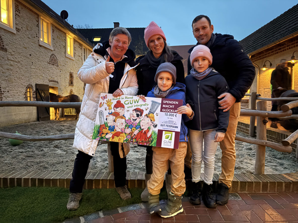 Carolin Feismann (links) erhält von Familie Rüschoff (rechts) stellvertretend für die GUW eine symbolische Spende in Höhe von 10.000 Euro für das tiergestützte Kinderhospiz Gut Feismann.
