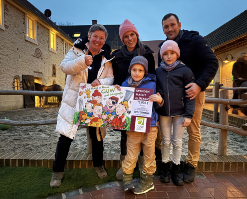 Carolin Feismann (links) erhält von Familie Rüschoff (rechts) stellvertretend für die GUW eine symbolische Spende in Höhe von 10.000 Euro für das tiergestützte Kinderhospiz Gut Feismann.